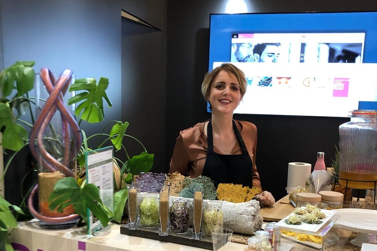 Stand d'animation culinaire avec préparations végétales et graines germées.